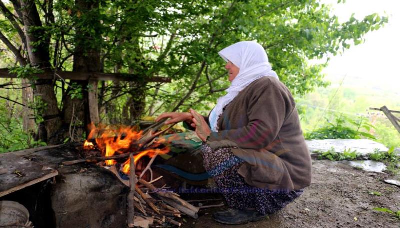 köylü kadın ateş yakıyor